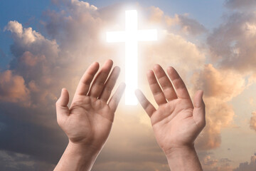 Religion. Christian man praying against sky with glowing cross, closeup - obrazy, fototapety, plakaty