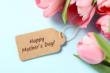 Happy Mother's Day greeting label and beautiful tulip flowers on light blue background