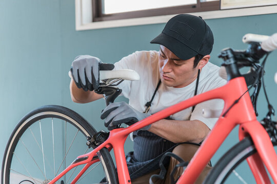 自宅のガレージでロードバイクを整備・メンテナンスする男性
