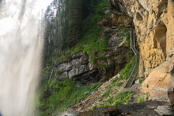 Fototapeta premium waterfall from a high cliff. water flow down.Streams of water crash on rocks and boulders. stormy stream of water with drops and splashes