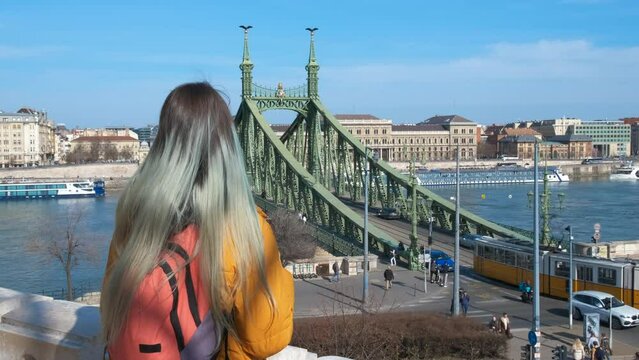 Girl looking out budapest street. A teen with turquoise hair looking at the budapest landscape by the Danube river.