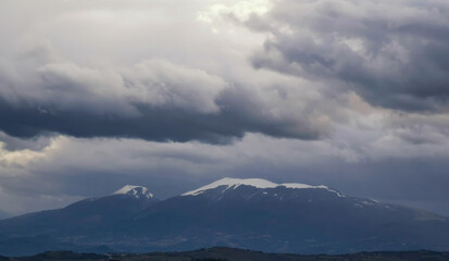 Montagne innevate in inverno e cielo coperto di grandi nuvole grigie