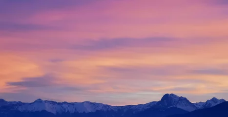 Deurstickers Tramonto luminoso viola e rosa sopra le montagne innevate © GjGj