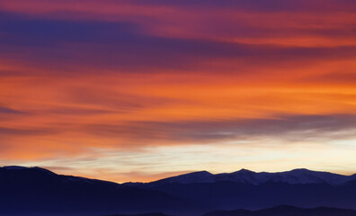 Nuvole rosse al tramonto sulla cime delle montagne