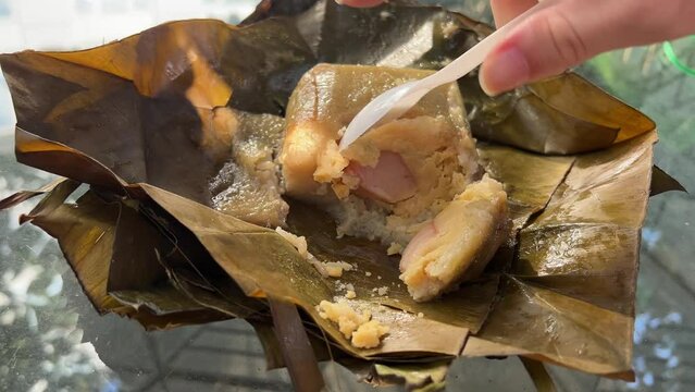  Vietnamese Chung Cake isolated on white. square glutinous sticky rice cake, stuffed with pork meat, green beans and wrapped in bamboo leaf. Traditional Vietnamese New Year Tet food.
