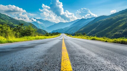 Straight asphalt road and mountain under blue sky. Highway and mountain background.