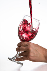 Action shot pouring red wine into a glass over a white background - 786753445