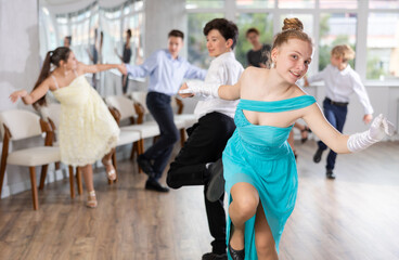 Fototapeta premium Group of festively dressed boys and girls dance a twist dance