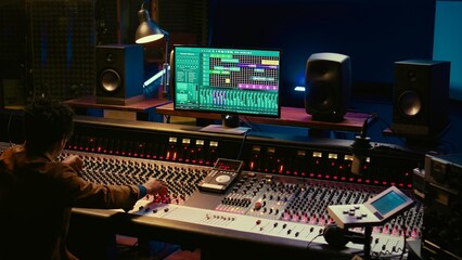 African american audio expert adding sound effects on tracks in post production, operating mixing...