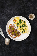 Omelet with spinach leaves with tuna sandwich and cream cheese and salt cucumber.Omelette on plate, scrambled eggs on black background, top view.