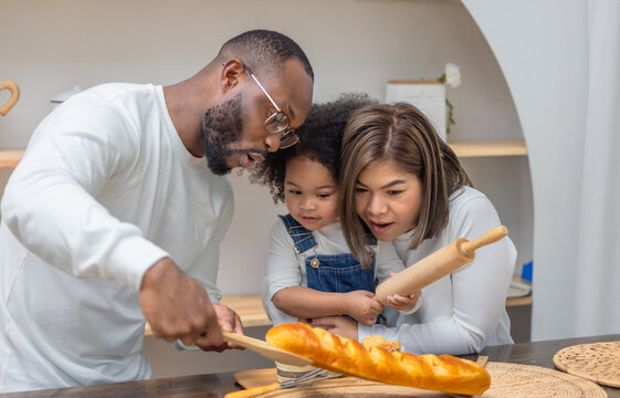 Multiracial Family Spending Quality Time Together Baking Bread in a Cozy Kitchen Setting