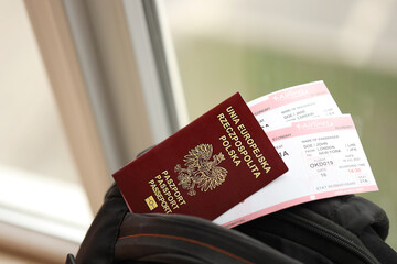 Poland passport with airline tickets on touristic backpack close up. Tourism and travel concept