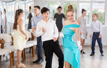 Fototapeta premium Girl in elegant dress posing while dancing in studio