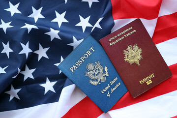 Fototapeta premium Passport of France with US Passport on United States of America folded flag close up
