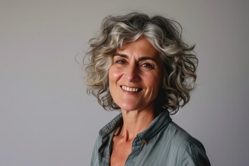Portrait of a smiling middle-aged woman with grey hair.