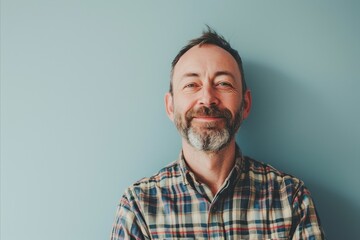 Portrait of happy mature man looking at camera over blue background.
