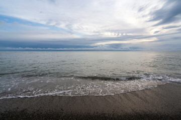 An incoming wave on the Black Sea coast against the sunset sky, Sochi, Krasnodar Territory, Russia