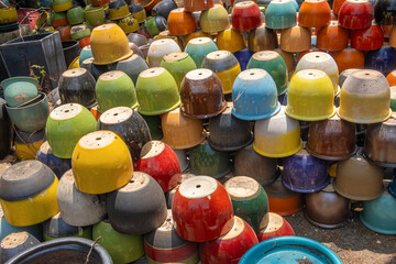 Outdoor storage of colorful flower pots at The Tao Hong Tai Ceramics Factory in Ratchaburi, Thailand