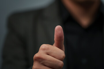 businessman in suit showing thumbs up sign or fingerprint scan