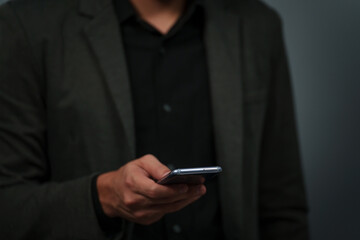 hand of businessman in suit using smartphone