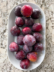 Fresh Plums on a Plate in a Bright Modern Kitchen Setting - 786772469