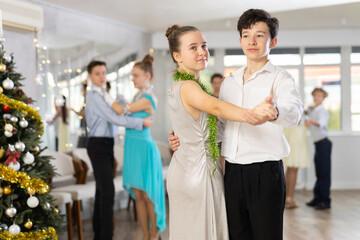 Enthusiastic adolescent dancers, girls and boys in elegant outfits practicing partner dance moves...