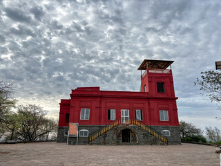 A red building with a sign on the front at Ralamandal, Indore, India.