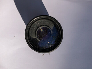 camera lens with fungus in the front element on a white background with direct natural lighting, broken lens, fungus lens, optics