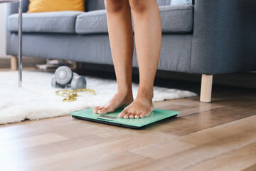 Woman Feet Standing on a Digital Scale Weighing Body at Living Room. Diet Checking Program. 
