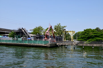 Fototapeta premium BANGKOK, THAILAND - April 17, 2024: crane for picking up garbage with waste sorting machines in Saen Saeb Canal at Khlong Kacha Pump Station in Thailand.