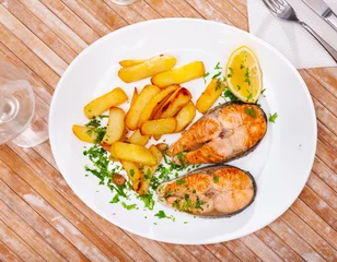 Foto op Canvas Grilled salmon steak served on plate with fried potato. Garnished fish ready-to-eat. © JackF