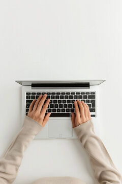 A woman is typing on a laptop with her hands on the keyboard