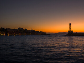 Old lighthouse in a port town at sunset (Chania, Crete, Greece)