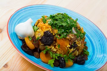 Fotobehang Pilaw with mutton, dried apricots, prunes and garlic - traditional uzbek dish © JackF