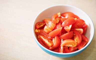 Tomato halves on a plate placed on a table with copy space left for use.