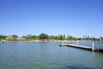 Fototapeta na wymiar Double sided boat dock stretching into cool spring waters of Kiwanis park lake, Tempe, Arizona 