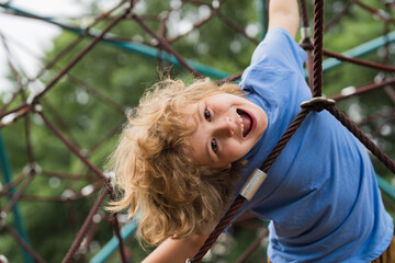 The outdoor playground for children in summer park. Kid play on playground under the tree. Portrait...