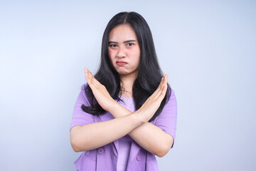 Serious woman showing cross hands gesture, demonstrating denial sign, rejecting something unwanted.