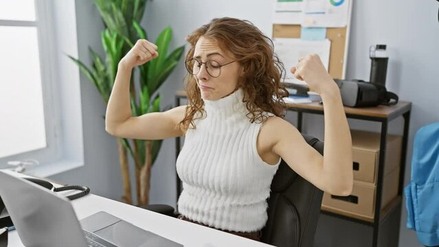 Radiant young woman beams with energy, confidently flexing her muscular arms at office. exuding strength, body fitness, she embraces a healthy lifestyle. workplace power house!