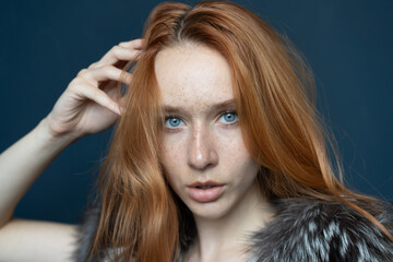 portrait of a young beautiful woman with red hair in the studio