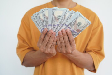 Close-up shot of a man's hands holding dollar bills, isolated. The crisp currency notes neatly held...