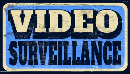 Aged and worn video surveillance sign on wood