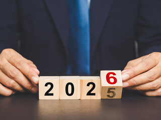 Flipping of 2025 to 2026 on wooden cubes for preparation of new year change.