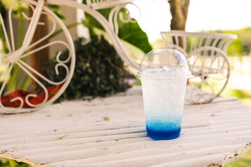 Blue soda soft drink with ice on the table with copy space