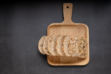 Top view of grain loaf bread stack on a tray with balck background