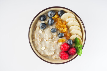 tasty nutritious oatmeal with fruits and berries on a white background