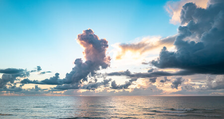 Sunset on sea. Beach sunrise with cloudy sky.