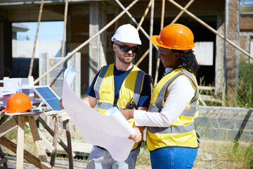 worker or architect reading blueprint paper for building house at construction site