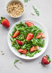 Fresh Strawberry Arugula Salad With Pine Nuts Served on a Bright Day