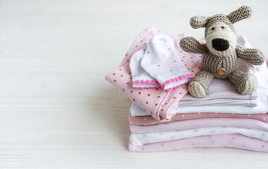 Stack of baby clothes, socks and knitted toy